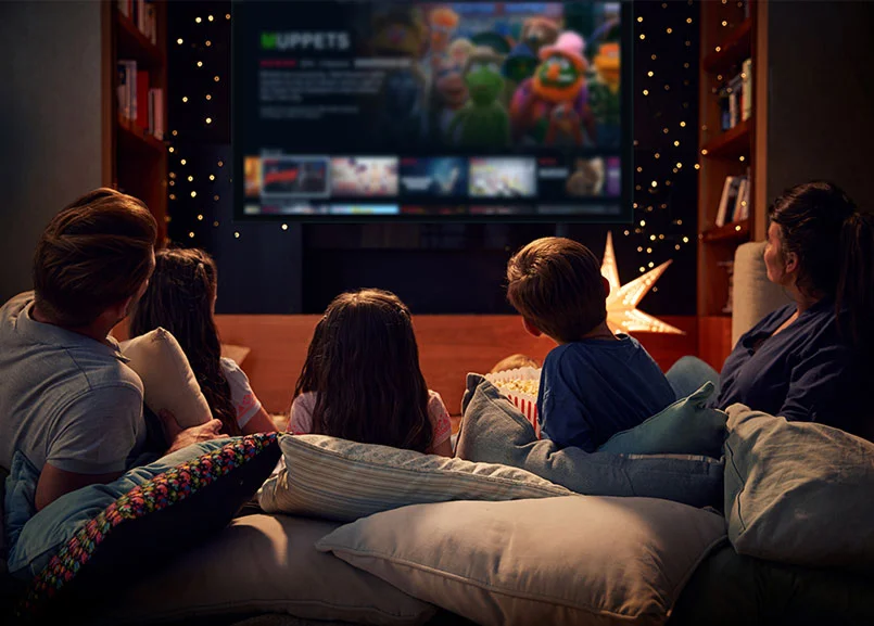 Rodzina oglądająca film na dużym ekranie w salonie smart home